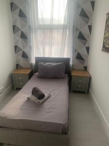 a small bedroom with a bed with two night stands at The big one High Street in Blackpool