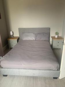 a bed in a bedroom with two nightstands and two tables at The big one High Street in Blackpool
