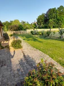 einen Garten mit einem Zaun und einem Pfad in der Unterkunft Les Cottages du Chateau de Werde in Matzenheim