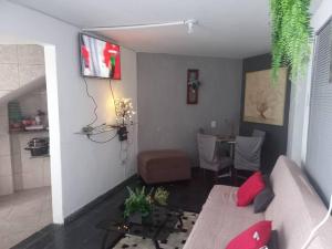 ein Wohnzimmer mit einem Sofa und einem Tisch in der Unterkunft Piscina Casa Floresta/Sta Teresa/Central/Contorno/Serraria Souza Pinto/Area Hospitalar in Belo Horizonte