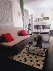 uma sala de estar com um sofá com duas almofadas vermelhas em Piscina Casa Floresta/Sta Teresa/Central/Contorno/Serraria Souza Pinto/Area Hospitalar em Belo Horizonte