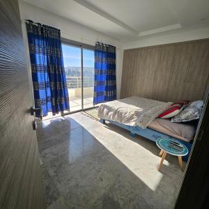 a bedroom with a bed and a large window at The cozy corner in Hammamet