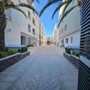 une rue vide entre deux bâtiments plantés de palmiers dans l'établissement The cozy corner, à Hammamet
