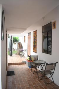 Cette chambre dispose d'une terrasse avec des chaises et une table. dans l'établissement Chakana House - Hostel Huanchaco, à Huanchaco