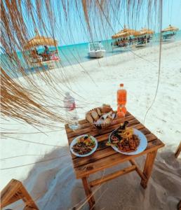 una mesa de picnic con platos de comida en una playa en Mahdia best Beach, en Mahdia