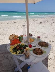 una mesa con platos de comida en la playa en Mahdia best Beach, en Mahdia
