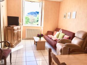 - un salon avec un canapé et une télévision dans l'établissement Gîte Léonline sur les hauteurs de Masevaux -au pied des Vosges, à Masevaux