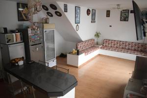 uma cozinha com um sofá e uma mesa num quarto em Chakana House - Hostel Huanchaco em Huanchaco