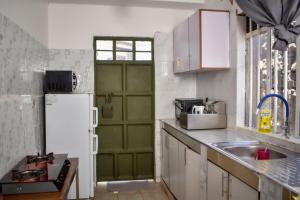 uma cozinha com uma porta verde e um frigorífico branco em Mella homes limuru em Kiambu