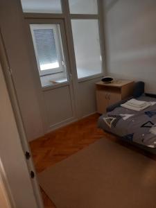 a small room with a bed and two windows at Veledar 2 in Čapljina