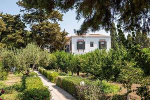 a house in the middle of a garden with trees at Calvocoressi Estate in Chios