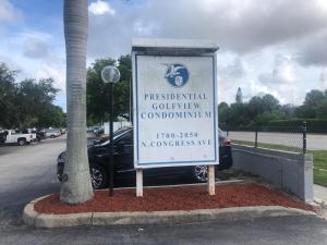 un panneau dans un parking à côté d'une voiture dans l'établissement Presidential Golfview Condominiums, à West Palm Beach