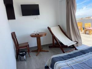 Cette chambre comprend un lit, une chaise et une table. dans l'établissement Habitación con vista al mar, à Pimentel