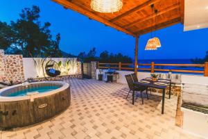 an outdoor patio with a jacuzzi tub at Casa Zoe Luxurious Retreat in Archangelos