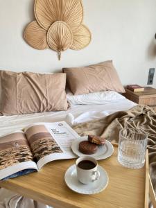 a book and a cup of coffee and a plate of food on a bed at Aden Suit Apart Otel in Fethiye