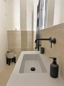 a bathroom with a sink with a faucet at Veneto Serviced Apartment by SupaStays in Rome
