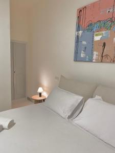 a bedroom with a white bed and a painting on the wall at Veneto Serviced Apartment by SupaStays in Rome