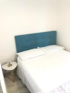a bedroom with a bed with a blue headboard and a table at Planeta Scalea in Scalea