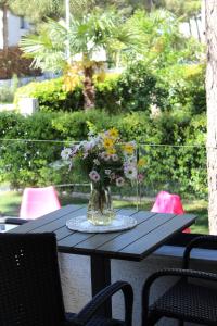 a vase of flowers sitting on top of a table at Vala Mar Apartament in Draç +11 photos