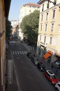 uma rua da cidade com carros estacionados na rua em Charming Milanese Aparment em Milão