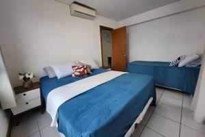 een slaapkamer met 2 bedden met blauwe lakens bij Melhor Vista de Salvador in Salvador