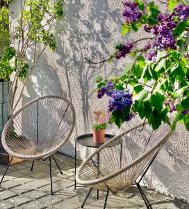 eine Terrasse mit 2 Stühlen und einem Tisch mit Blumen in der Unterkunft Bohlinger Seeapartments in Bohlingen