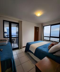 a bedroom with a bed and a view of the ocean at Melhor Vista de Salvador in Salvador