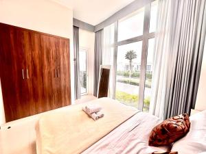 a bedroom with a bed with a large window at Amazing 1Bedroom Plus Maid in Avencia at Damac Hills 2 in Dubai