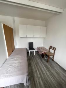 a bedroom with a bed and a chair and cabinets at Студия in Kouvola
