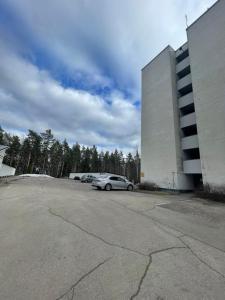 a parking lot with cars parked next to a building at Студия in Kouvola