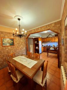 a dining room with a wooden table and chairs at Casa Jesús in Muxia