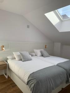 a bedroom with a large white bed with pillows at Apartamentos Lux Carrión in Carrión de los Condes