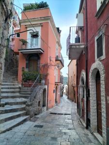 ラグーザにあるSan Filippo Neri - CAMEREのピンクの建物が並ぶ旧市街の路地