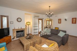 a living room with a couch and a fireplace at Vivenda Solar dos Pescadores in Armação de Pêra