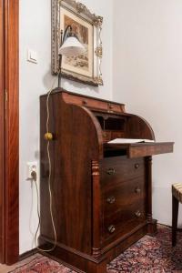 a lamp on top of a wooden dresser in a room at House w/Castle View Garden, Wine, Garage, Netflix in Budapest