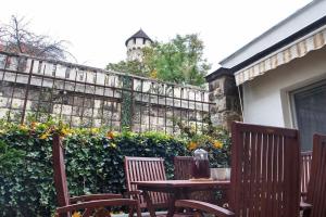 a table and chairs sitting in front of a fence at House w/Castle View Garden, Wine, Garage, Netflix in Budapest