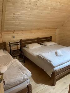 a room with two beds in a wooden cabin at Vichnashi in Mestia