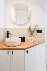 un comptoir de salle de bain avec un lavabo et un miroir dans l'établissement We Parisian The Marais Cozy Home, à Paris 16 autres photos
