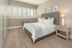 a bedroom with a large bed with white pillows at CAPE TOWN - MOUILLE POINT - SEA VIEW APARTMENT in Cape Town