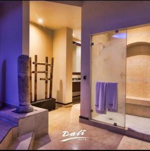 ein Badezimmer mit Glaswand und Handtüchern in der Unterkunft Hotel Dali in Reynosa