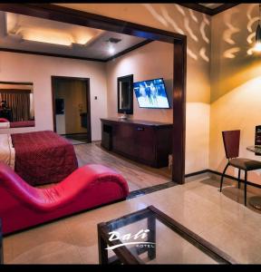 a bedroom with a red couch and a tv in a room at Hotel Dali in Reynosa