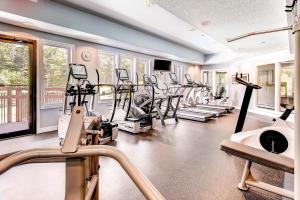 un gimnasio con un montón de cintas de correr y elípticas en Sunrise Mountain Village, en Killington