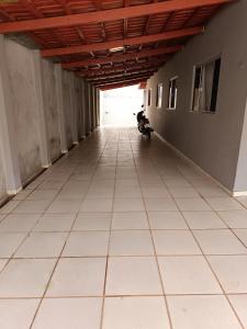 an empty hallway with a person sitting on a scooter at Home flat in Araguaína