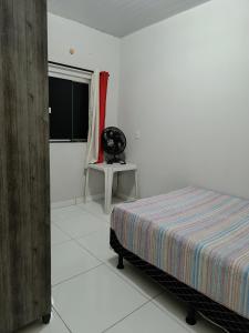 een slaapkamer met een bed, een raam en een tafel bij Home flat in Araguaína
