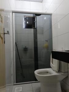 a bathroom with a toilet and a glass shower at Home flat in Araguaína