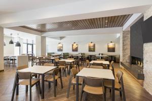 un restaurant avec des tables, des chaises et une cheminée dans l'établissement Fairfield Inn & Suites by Marriott Minneapolis North/Blaine, à Blaine