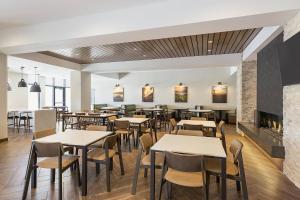 a restaurant with tables and chairs and a fireplace at Fairfield Inn & Suites by Marriott Minneapolis North/Blaine in Blaine