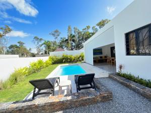 una casa con piscina y 2 sillas en Villa Achille, en Las Terrenas