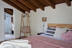 a bedroom with a bed with a pink comforter at Casa acogedora y reformada junto al Mar Cantábrico in Bárcena de Cicero