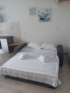 ein weißes Bett mit zwei Handtüchern darüber in der Unterkunft Apartment Roza in Cres